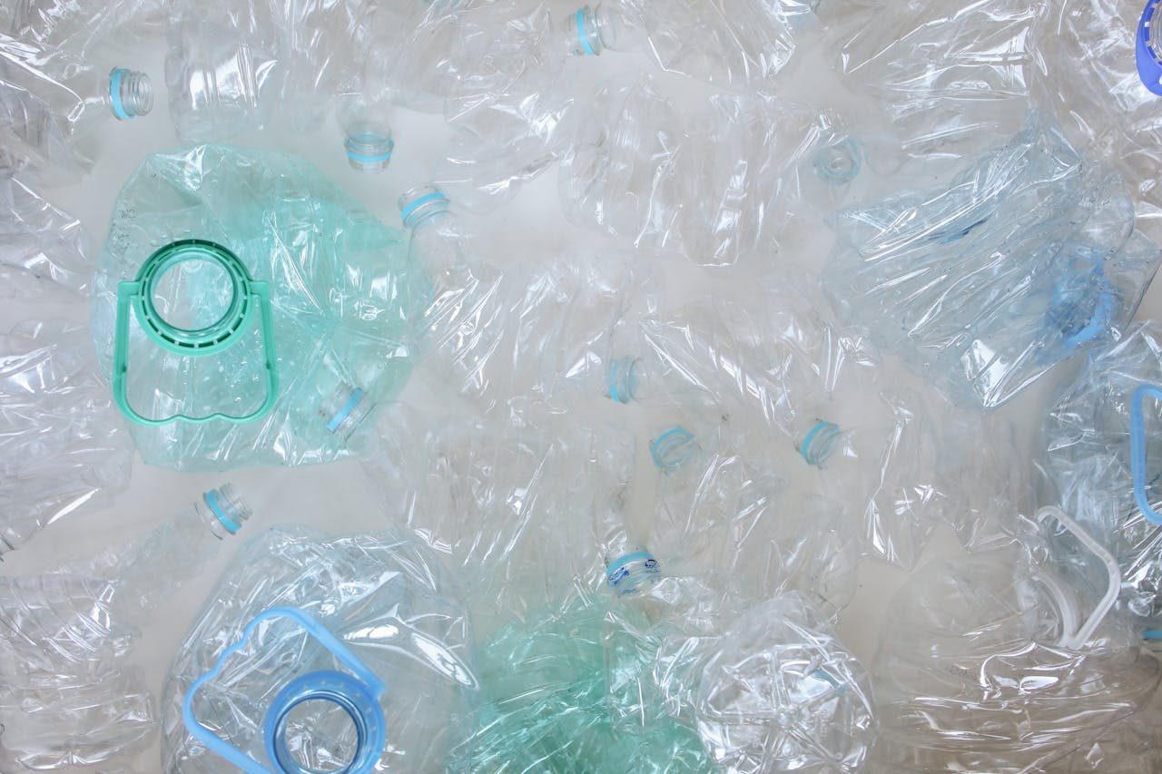 about-bg Top-view of crushed plastic bottles prepared for recycling, promoting sustainability.
