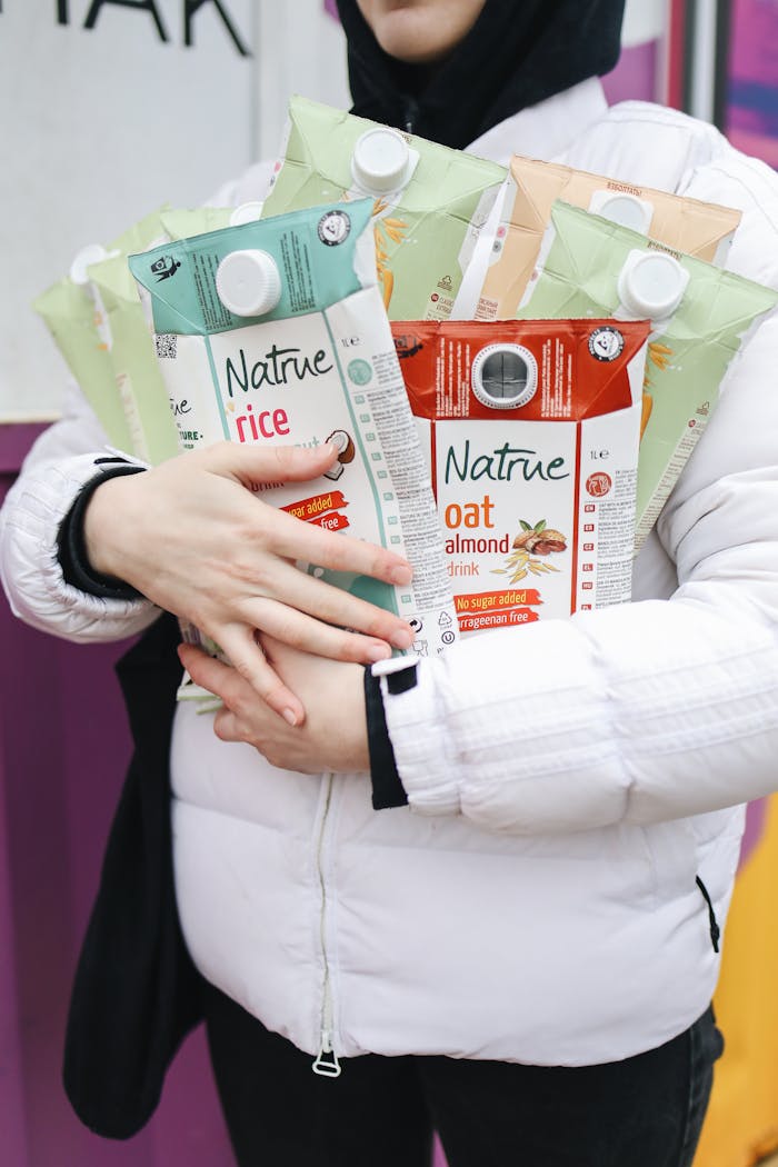 who-we-are Person holding various eco-friendly beverage cartons showcasing sustainability.